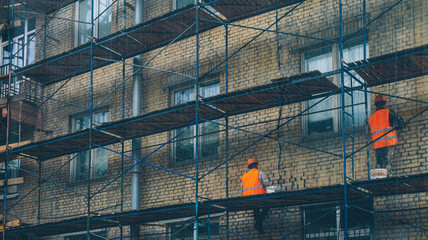 workers repair the facade of the building © fedorovekb