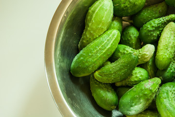 Fresh green cucumbers in an aluminum bowl