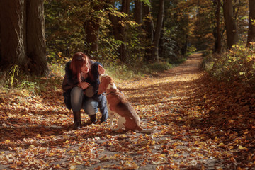 Young beautiful girl playing with a dog in the park.