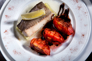 cod grilled with vegetables in white plate