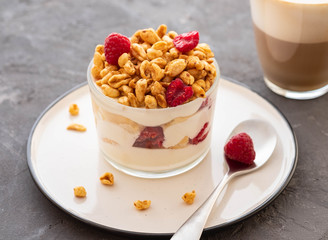 Fresh yoghurt with rasberries and coffee in clear glass. Raspberries in white bowl. Healthy morning breakfast.