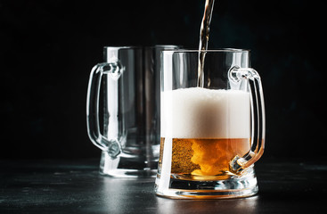 Glasses with czech light beer, dark bar counter, selective focus