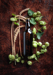 Bottle of beer, grain and hops on a vintage background.
