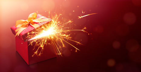 Red open gift box with sparkler