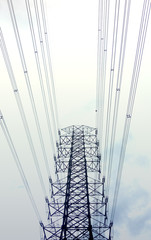 High voltage cables on high tower with early cloudy sky background