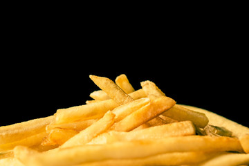 close up of french fries pile on black background