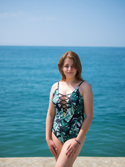 Portrait of beautiful young woman in swimsuit on sea background