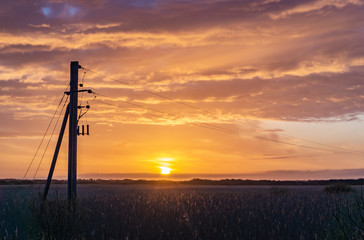 Sunrise with power masts in the foreground