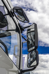 Rear view mirrors against a blue sky