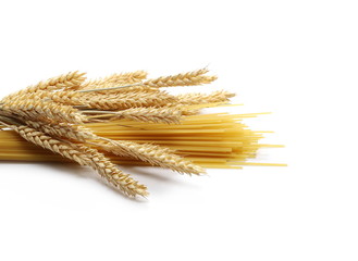 Dry wheat ears, grain with raw pasta noodles for spaghetti isolated on white background
