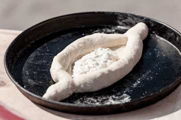 Cooking khachapuri in pan on kitchen table. Culinary recipe concept