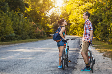 Fototapeta premium Young couple biking on a forest road in a sammer day. active recreation, sport, healthy lifestyle