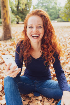 Vivacious laughing young woman in an autumn park