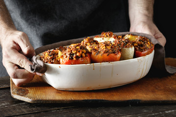 Male hands holding cooked stuffed peppers Healthy vegetarian food