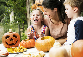 Naklejka premium Young kids carving Halloween jack-o'-lanterns