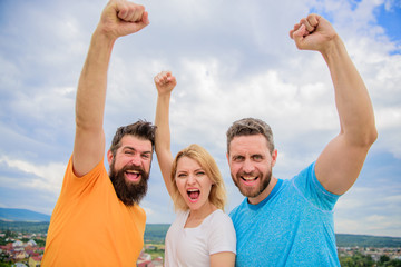 Woman and men look confident successful sky background. Threesome stand happy confidently with raised fists. Behaviors of cohesive team. Celebrate success. Yes we can. Ways to build сohesive team