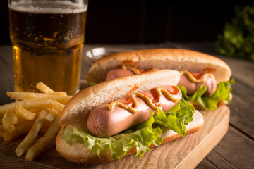 Photo of barbecue grilled hot dog with yellow mustard and ketchup on wooden background. Hot dog...