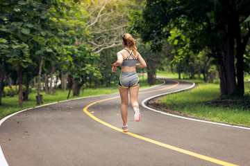 Woman exercising and jogging outdoors in nature at the park