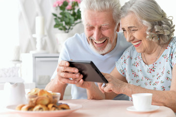 happy beautiful senior couple using tablet  at home