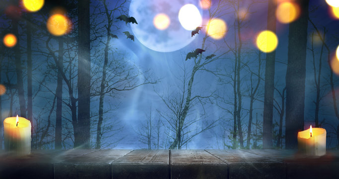 Halloween night scary autumn forest with wooden table background. Focus is on the table
