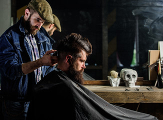 Barber styling hair of brutal bearded client with clipper. Hipster lifestyle concept. Hipster...
