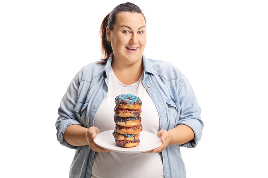 Oveweight female holding a pile of doughnuts on a plate