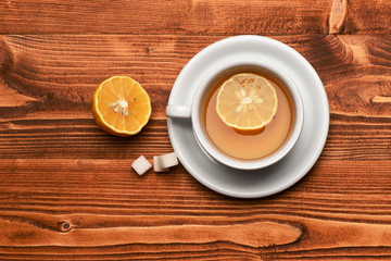 Hot beverage with sugar cubes on wooden background