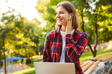 Amazing lady student listening music with earphones.