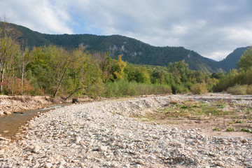 Bright autumn day on the forest river. Kurdzhips river in the Krasnodar region.