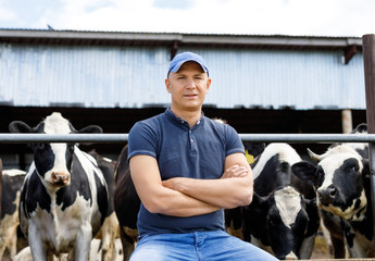 portrait of a farmer among cows on a farm
