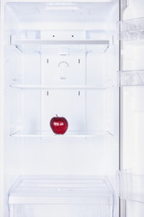 one ripe red apple in fridge