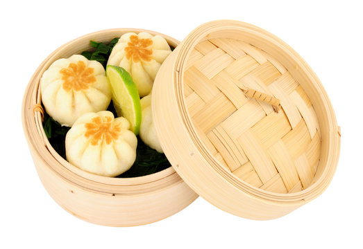 Oriental steamed dumplings in a traditional bamboo steamer isolated on a white background