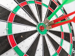 Close Up of Dart Holes on Dart Board Due to Throwing Darts Multiple Times. Four Darts Hit the Red Bullseye