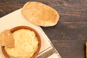 Background image of humus with pitta bread on a dark wooden background 