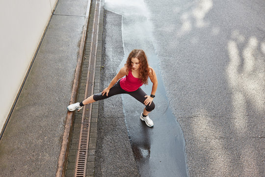 Sportliche junge Frau beim gesunden Dehnen