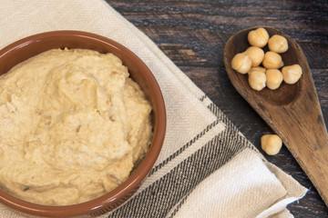 Background image of humus and chick peas on a wooden background 
