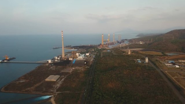 Aerial view Power station on the sea coast, Jawa island. Larger Industrial power plant in Indonesia. Power Plant cables and wires. 4K, aerial footage.