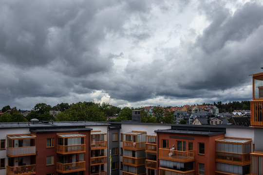 Dark summer  storm clouds over residential city buildings and rooftops.
