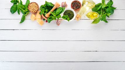 Traditional basil pesto sauce. Basil, parmesan cheese, olive oil. Top view. On a white wooden background. Free space for text.