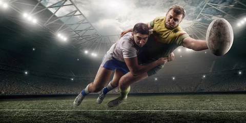 Zelfklevend Fotobehang Two male Rugby players fight for the ball in flight on professional rugby stadium © Alex