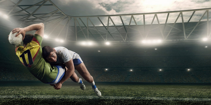 Two male Rugby players fight for the ball in flight on professional rugby stadium - Powered by Adobe