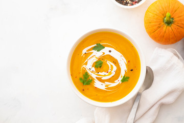 Pumpkin soup with cream and pumpkin seeds isolated on white background. Autumn concept.