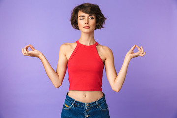 Image closeup of relaxed woman 20s in casual wear holding fingers together for meditation, isolated...