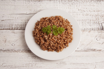 Cooked buckwheat on white wooden background. Healthy food.