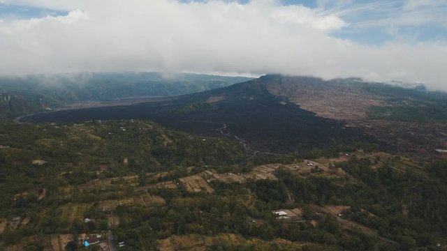 Volcano, mountains, sky with clouds, traces of lava on the ground. Aerial view of Mount Batur Volcano in Kintamani. Bali volcano, also referred to as Kintamani is popular sightseeing destination in