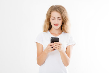 Young beautiful woman in t shirt using her smartphone isolated on white background. Sexy blond girl chating with friend or shopping online. Copy space