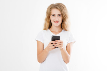 Young beautiful woman in t shirt using her smartphone isolated on white background. Sexy blond girl chating with friend or shopping online. Copy space