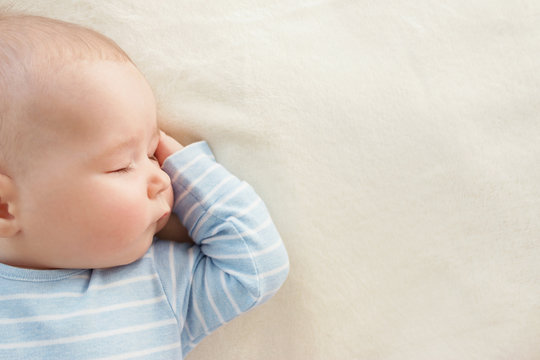 Baby sleeping covered with soft white blanket
