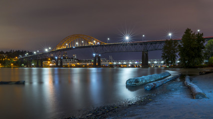 Obraz premium Patullo Bridge, Surrey, British Columbia, Canada. Long exposure of the bridge over the water. Sky Train Bridge.