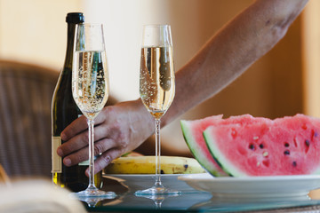 Two tall glasses with sparkling wine. Close watermelon and banana